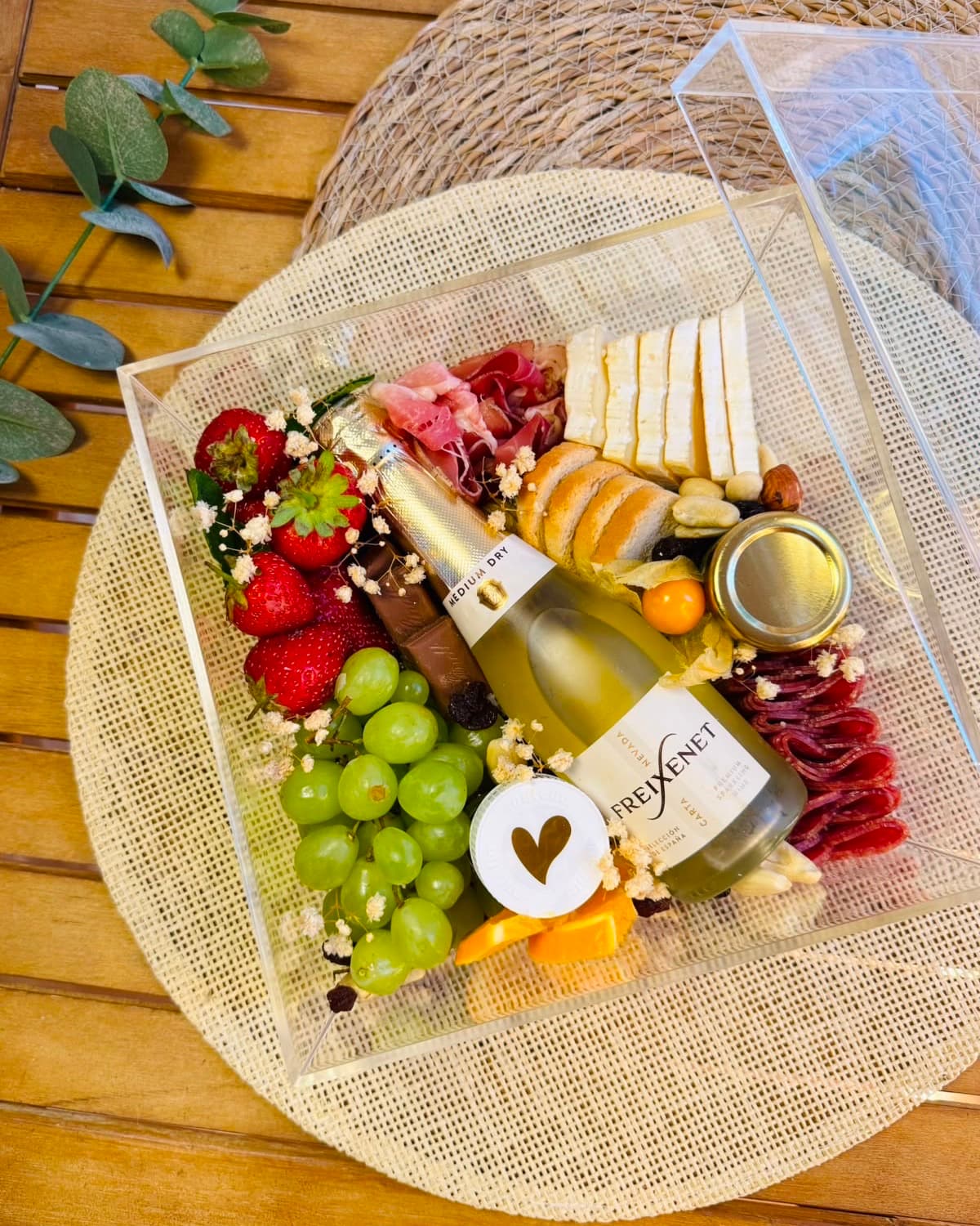 Geöffnete Acryl-Box Celebrate mit Freixenet-Sekt, Brie und Parmaschinken